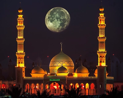 Illuminated Domes and Minarets: The image prominently showcases two tall minarets and a large dome, both brightly lit with golden lights, creating a striking contrast against the dark night sky.
Full Moon: Positioned between the minarets, a full moon is visible, adding a serene and celestial element to the scene.
Foreground Structures: The foreground includes additional buildings with arched windows illuminated in red, adding to the overall vibrant and festive atmosphere.
Arabic Text: There is a green illuminated sign with Arabic text, indicating the religious or cultural significance of the location.
Nighttime Setting: The overall setting is at night, with the artificial lighting emphasizing the architectural beauty and spiritual ambiance of the place.
The image is rich in cultural and religious significance, capturing the essence of a revered site during a special occasion or pilgrimage